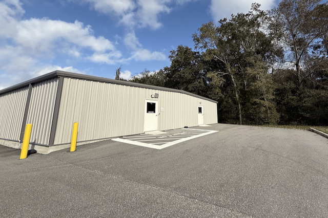 Exterior of Space Savers Storage’s climate-controlled facility in Mobile, AL, featuring secure gate code entry and affordable $18 starting rates.